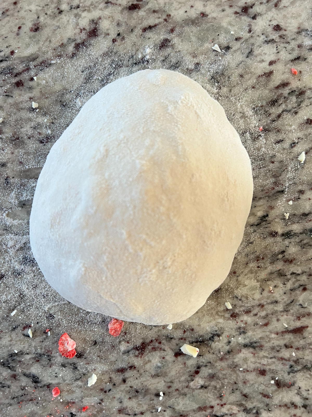 The strawberry white chocolate dough is shaped into a round boule.