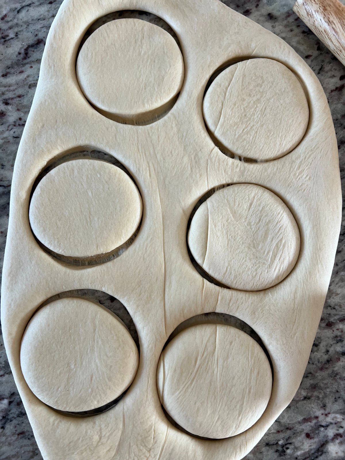 The dough has been cut into round donut shapes.
