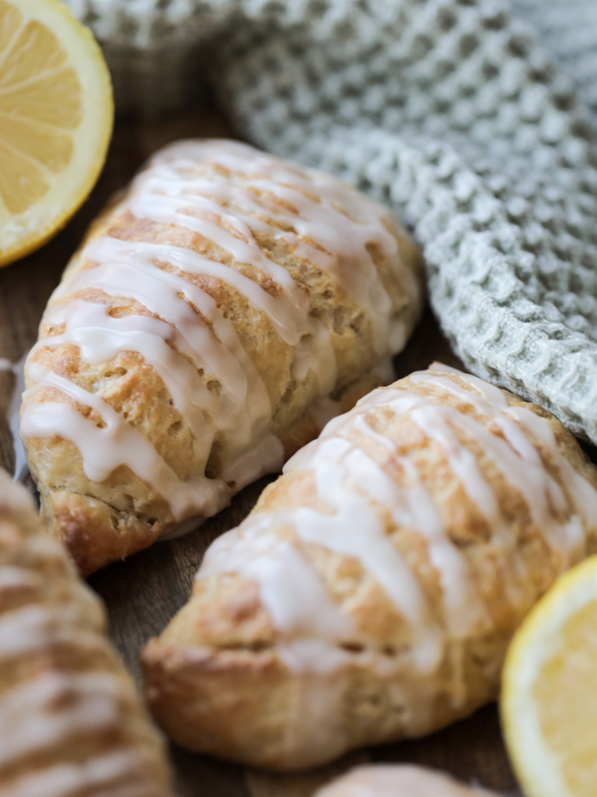 Several sourdough discard lemon scones sit on a wooden cutting board. 