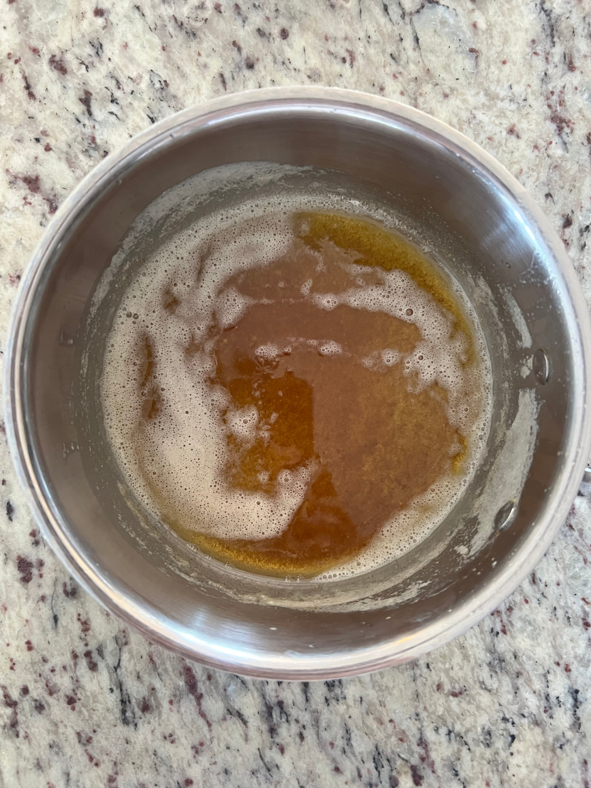 A medium sized saucepan sits with the freshly browned butter. 