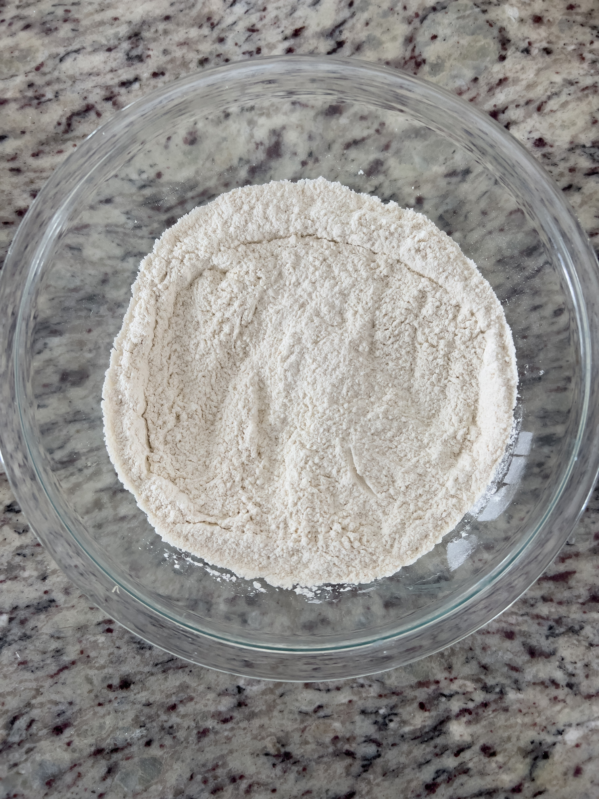 The dry ingredients for the sourdough brown butter chocolate chip skillet cookie sits in a glass mixing bowl.