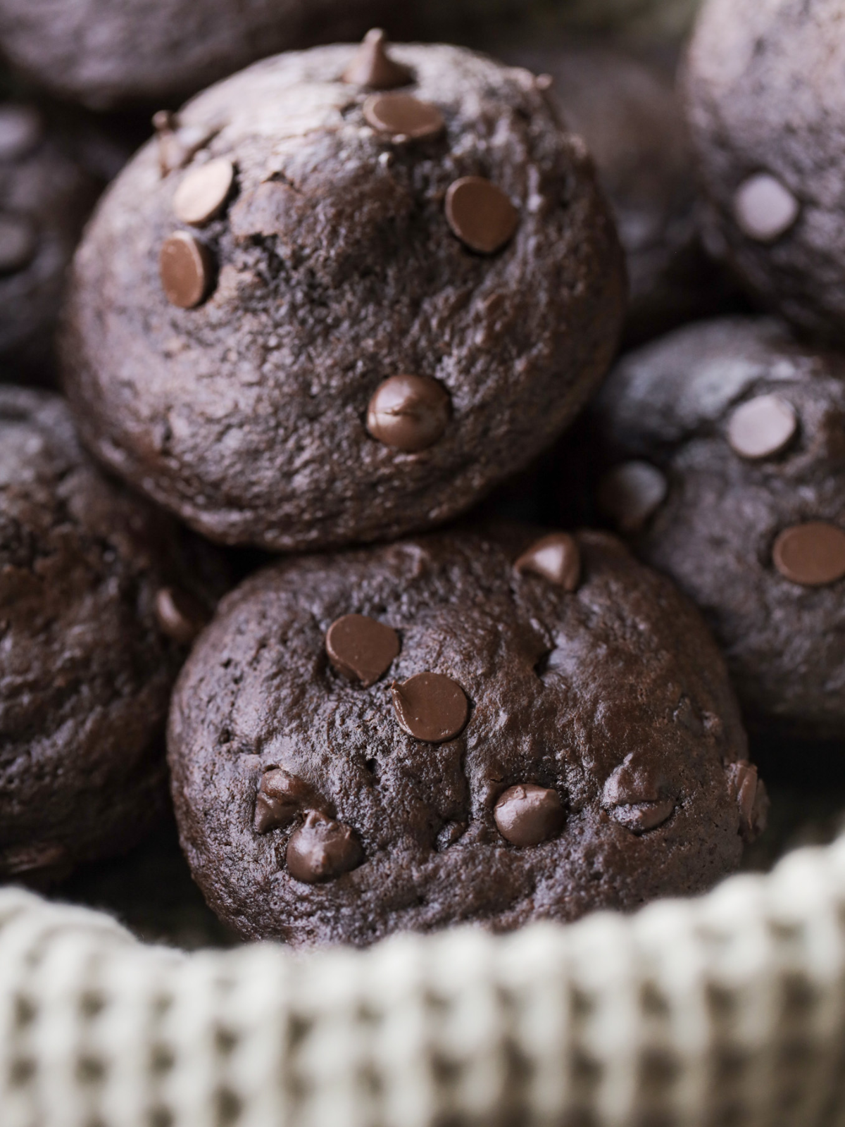 From-scratch double chocolate sourdough muffins sit in a basket. 