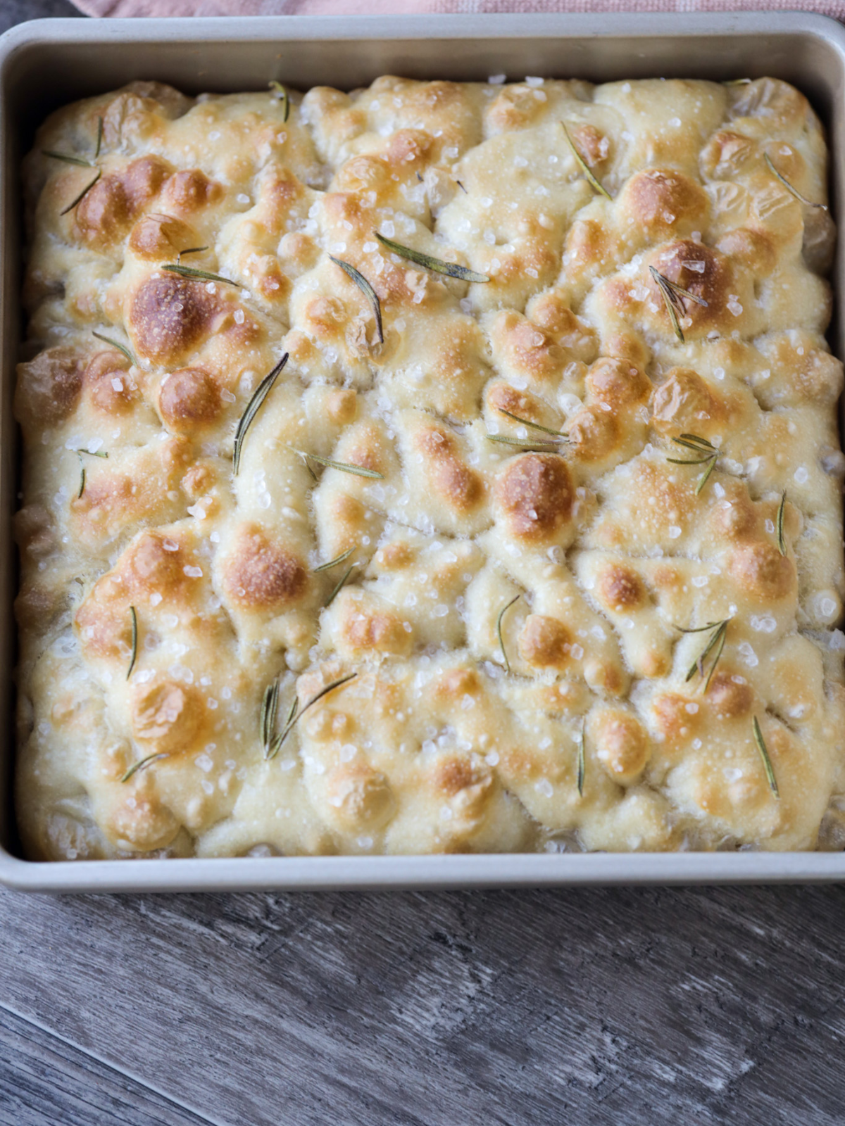 The sourdough focaccia dough is fresh out of the oven and golden brown. We will let it cool for 30-60 minutes before slicing and serving.