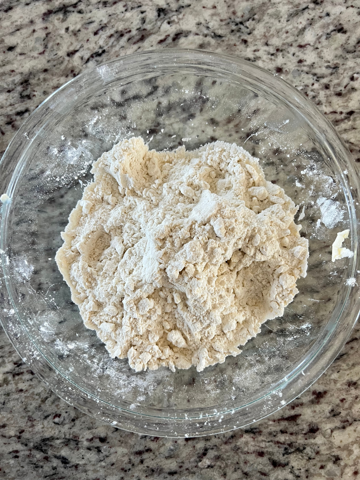 The dry ingredients and the grated butter are combined and sit in a mixing bowl for the sourdough lemon scones.
