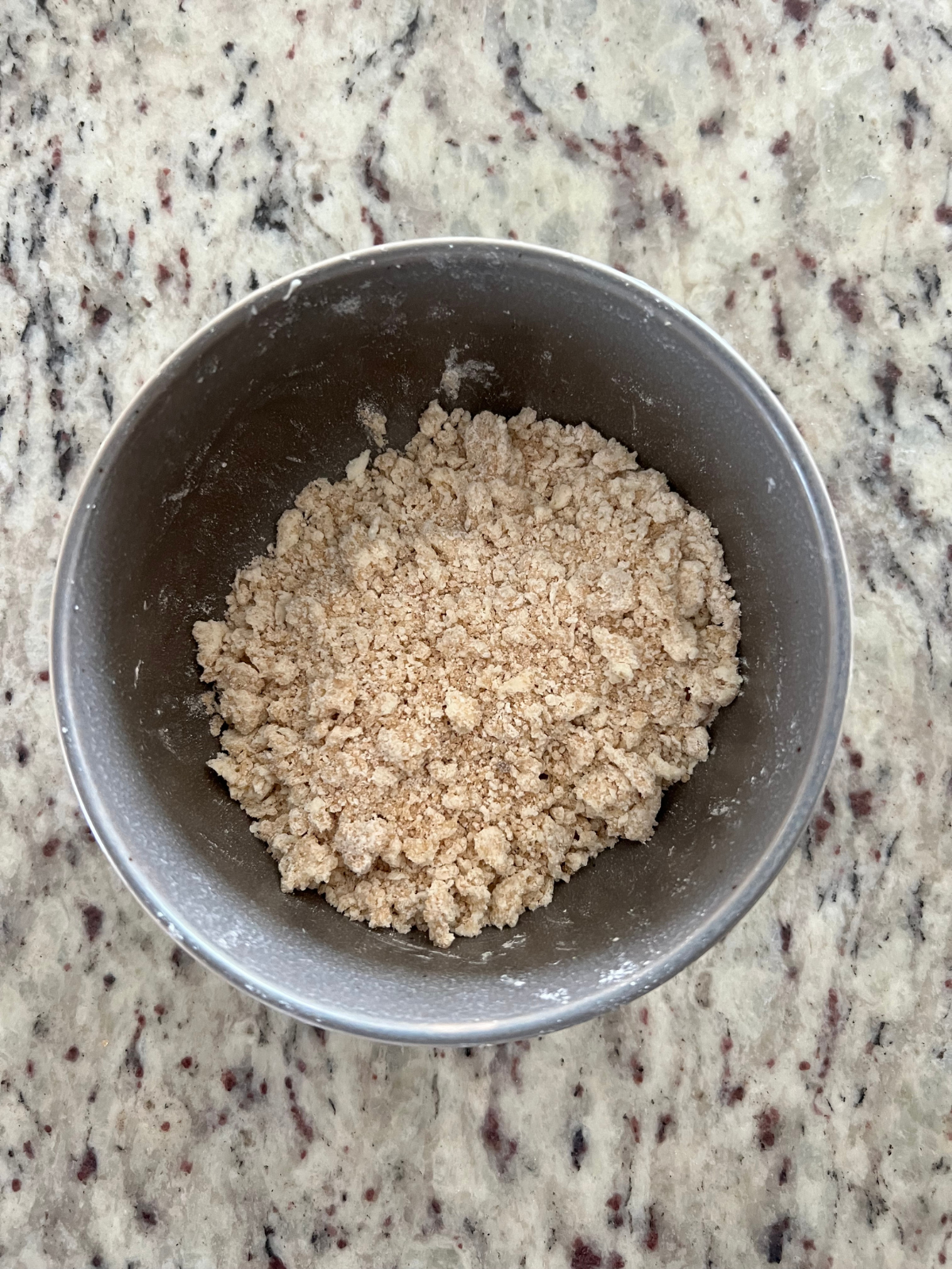 Streusel crumble sits in a bowl preparing to top the sourdough strawberry cream cheese buns.