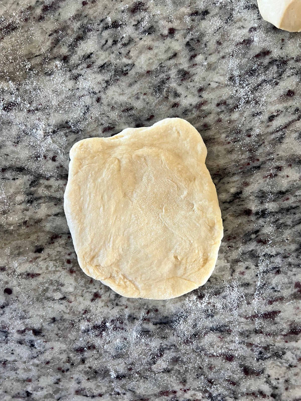 The sourdough hot dog bun dough is shaped into a 4x6 inch rectangle.