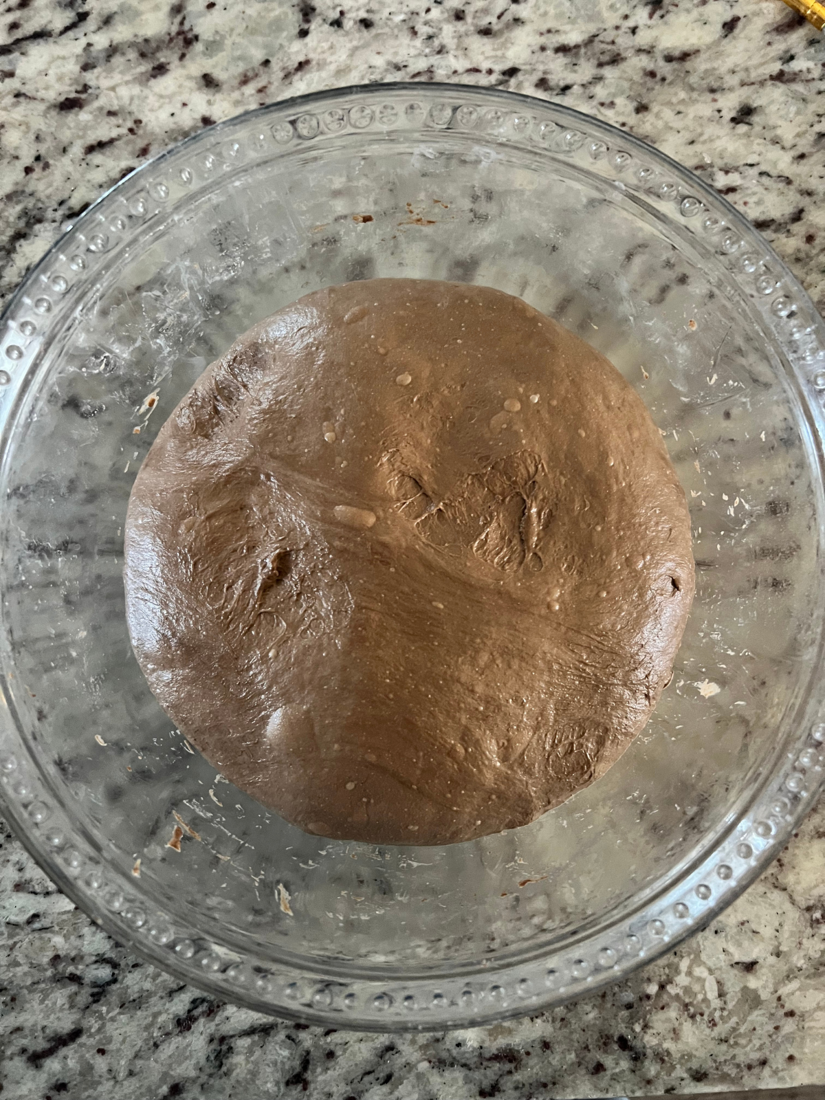 The sourdough chocolate and coffee bread is shown mid bulk-ferment. You can see it is doming and bubbling.