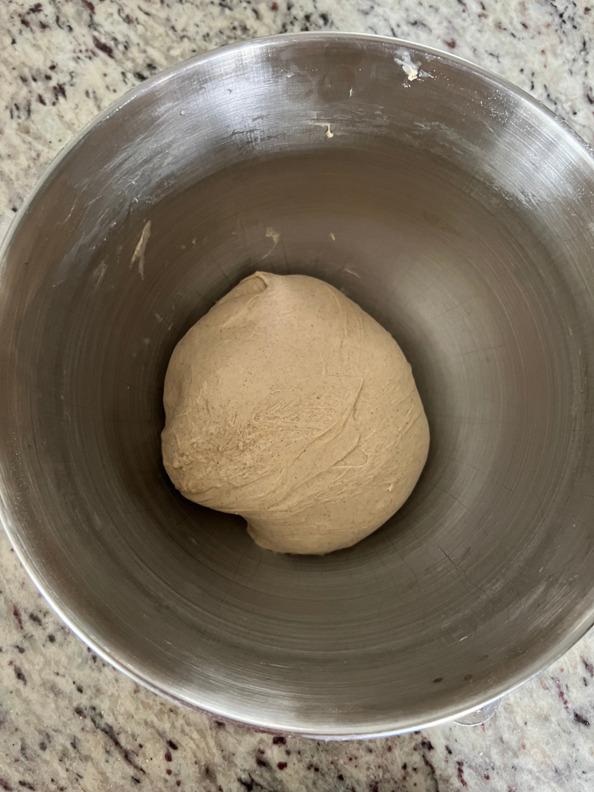 The sourdough cinnamon crunch bagel dough rests in the bowl of a stand mixer after being kneaded for 5-7 minutes on high.