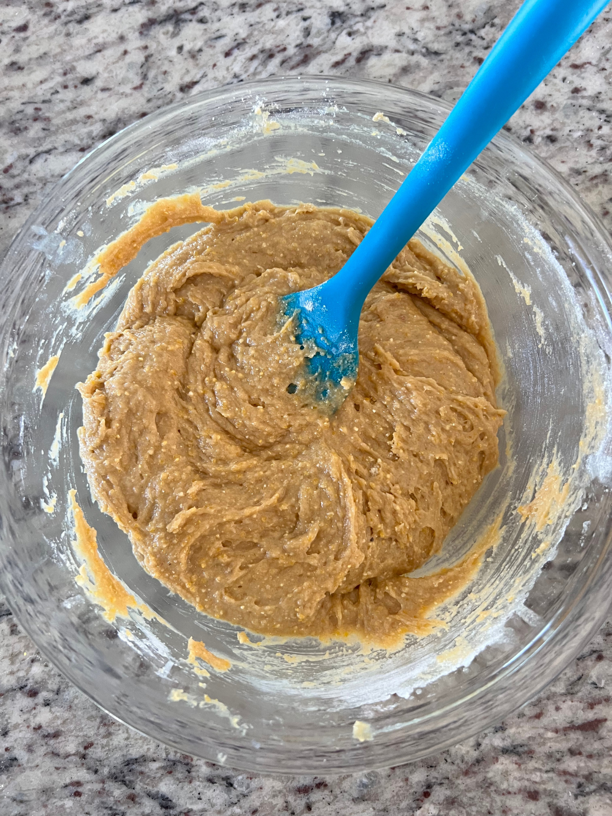 The sourdough cornbread cookie dough sits in a glass mixing bowl.