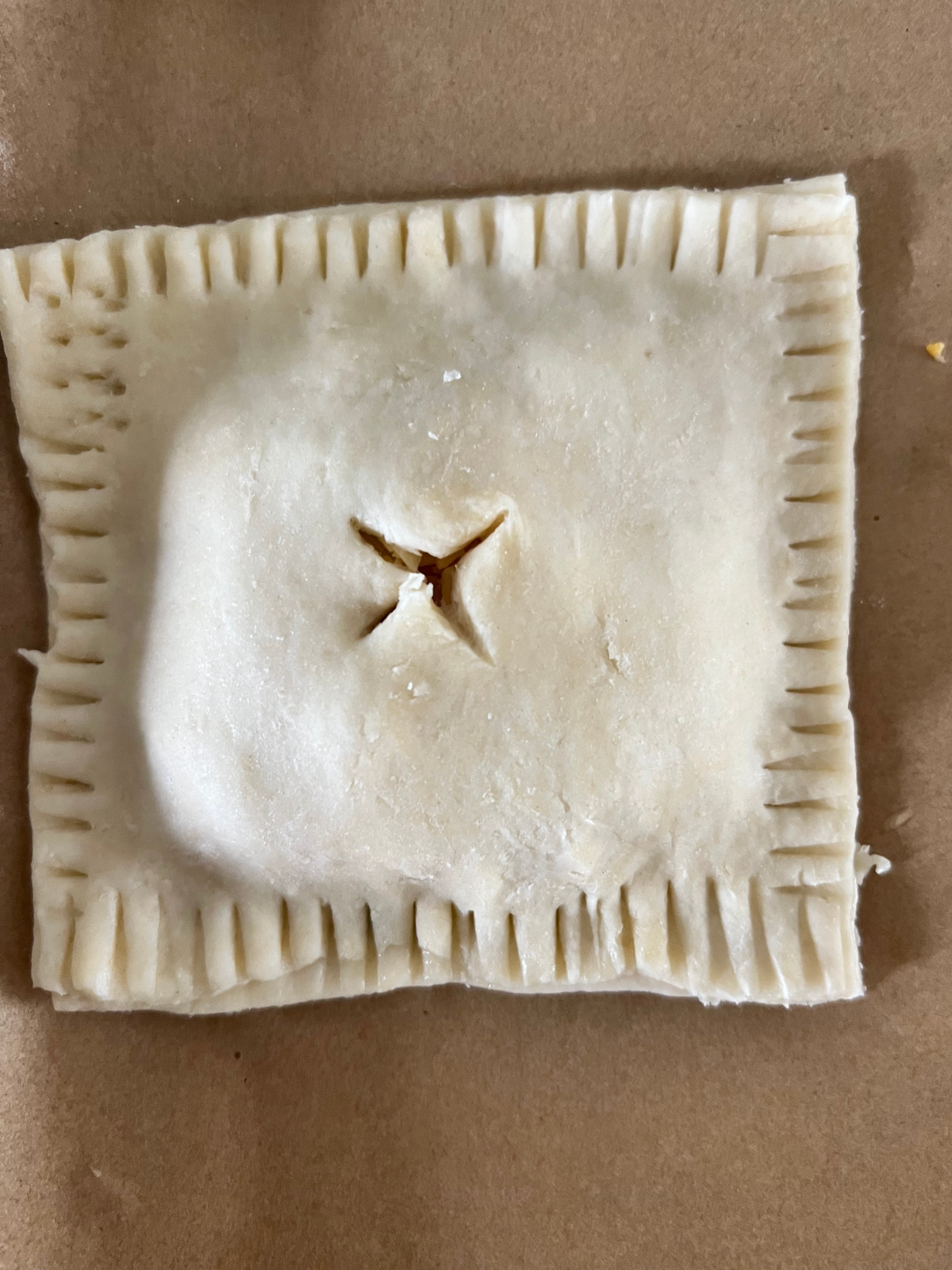 The sourdough discard hand pie is shown crimped and cut with an X on top. They will chill before going into the oven.