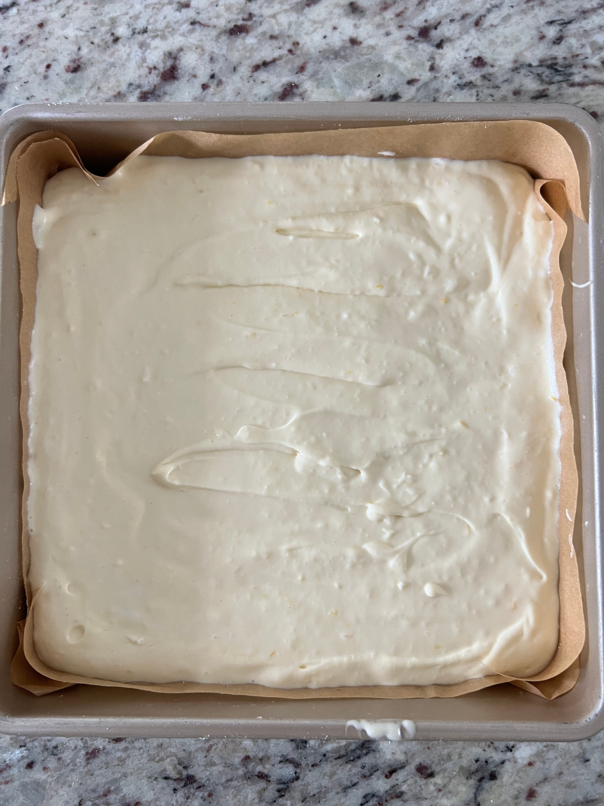 The cheesecake batter sits in the baking pan preparing to go in the oven.