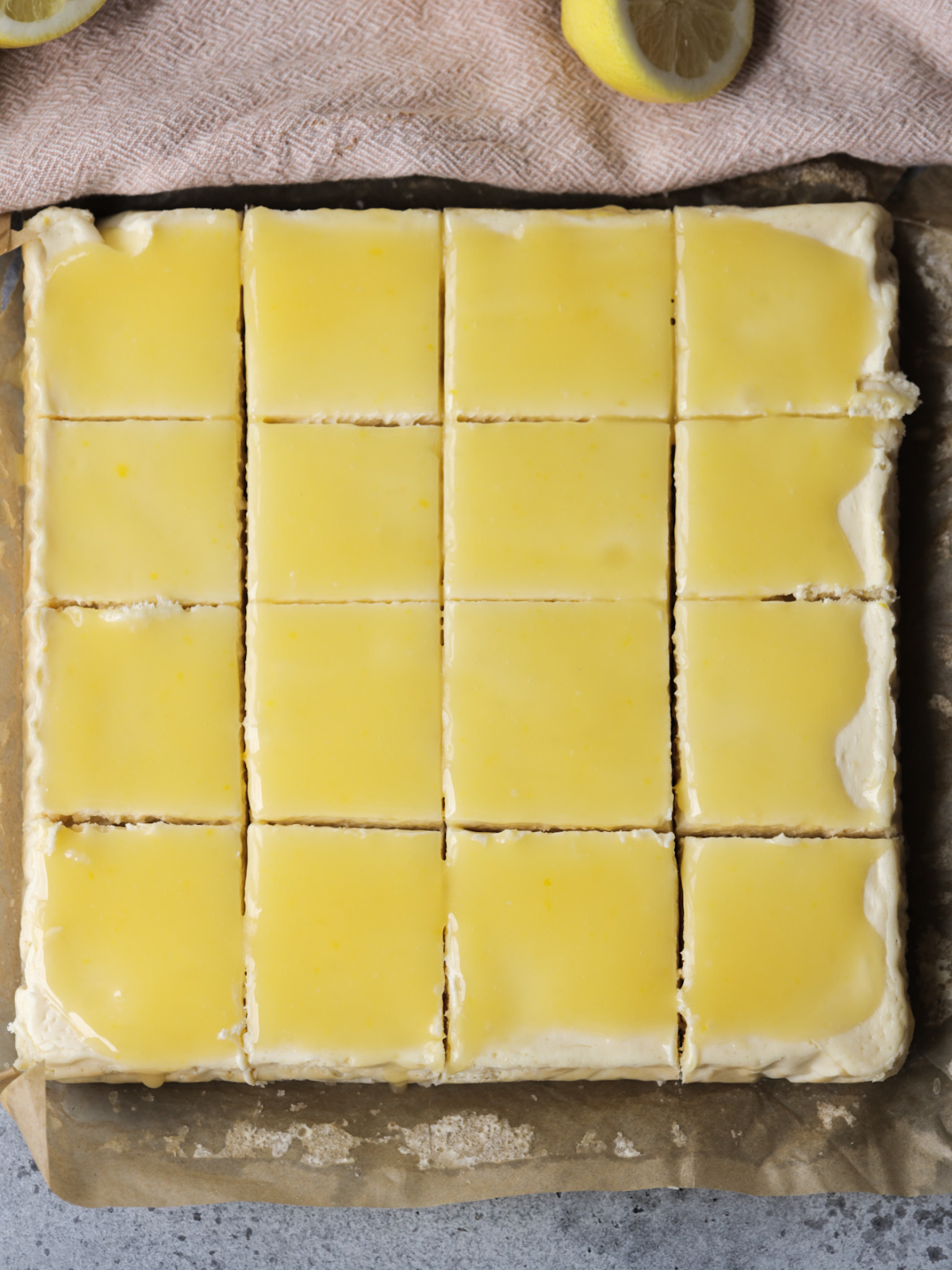 The lemon curd has been spread over the top of the lemon cheesecake and cut into 16 squares.