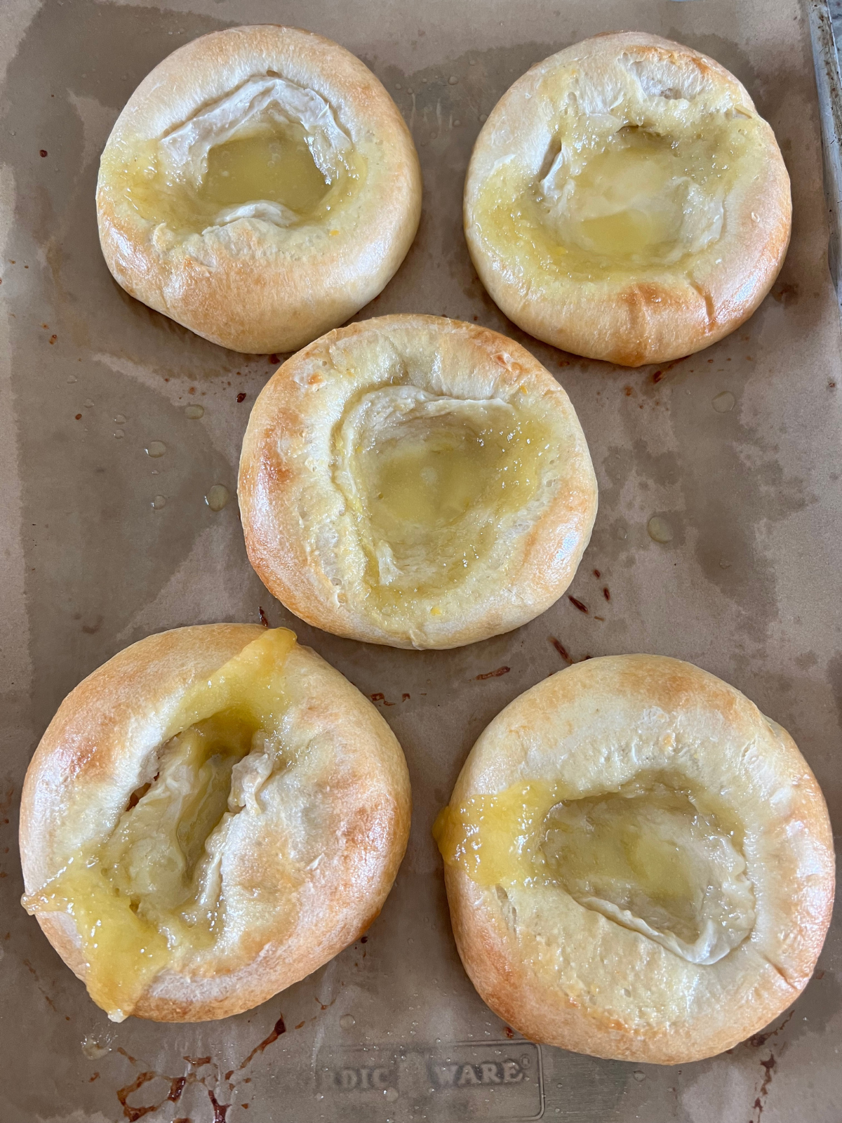 The lemon curd cream cheese sourdough buns are fresh out of the oven. They will be drizzled with icing.