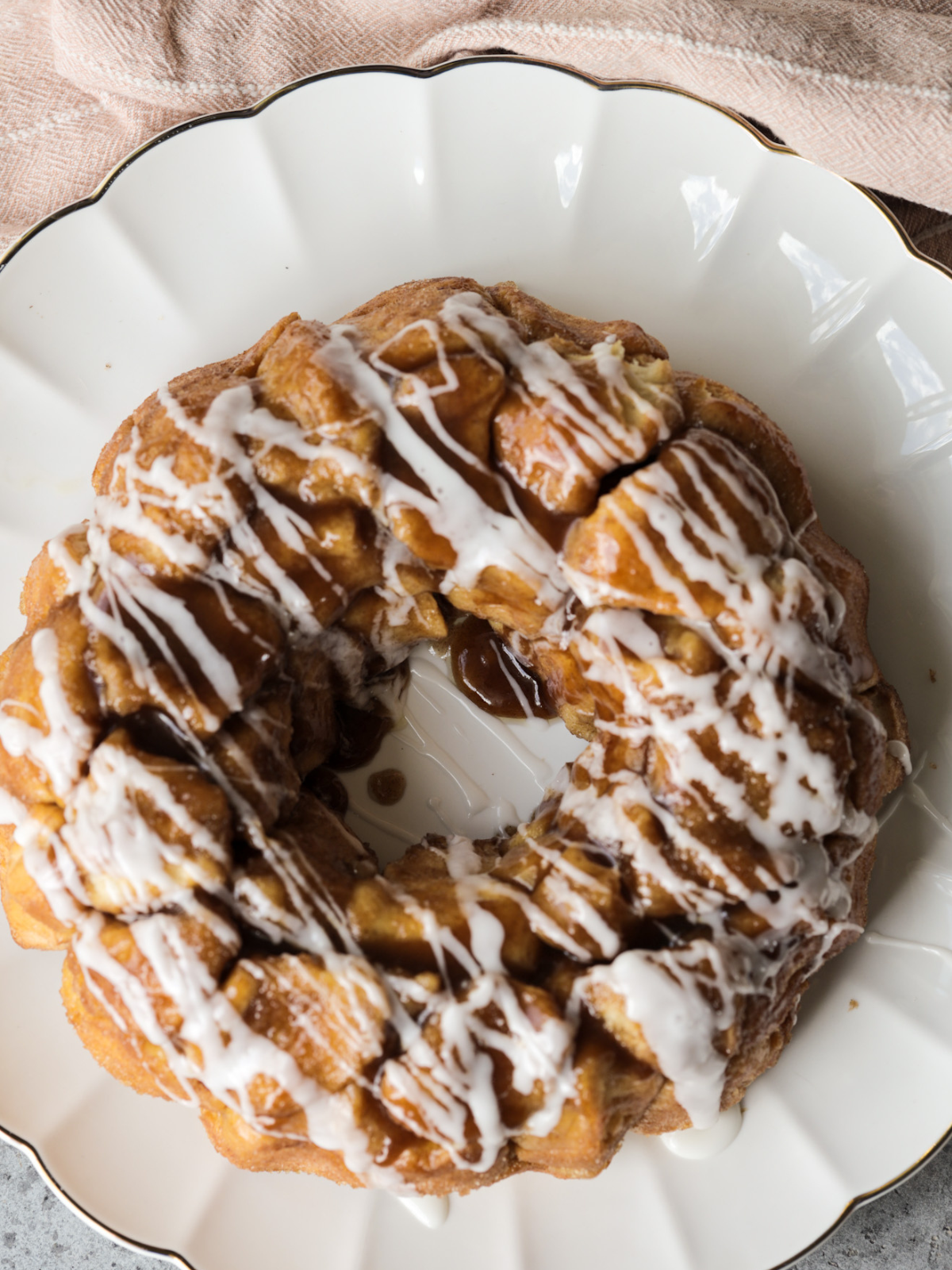 The full sourdough monkey bread with vanilla icing is shown on a serving plate. 