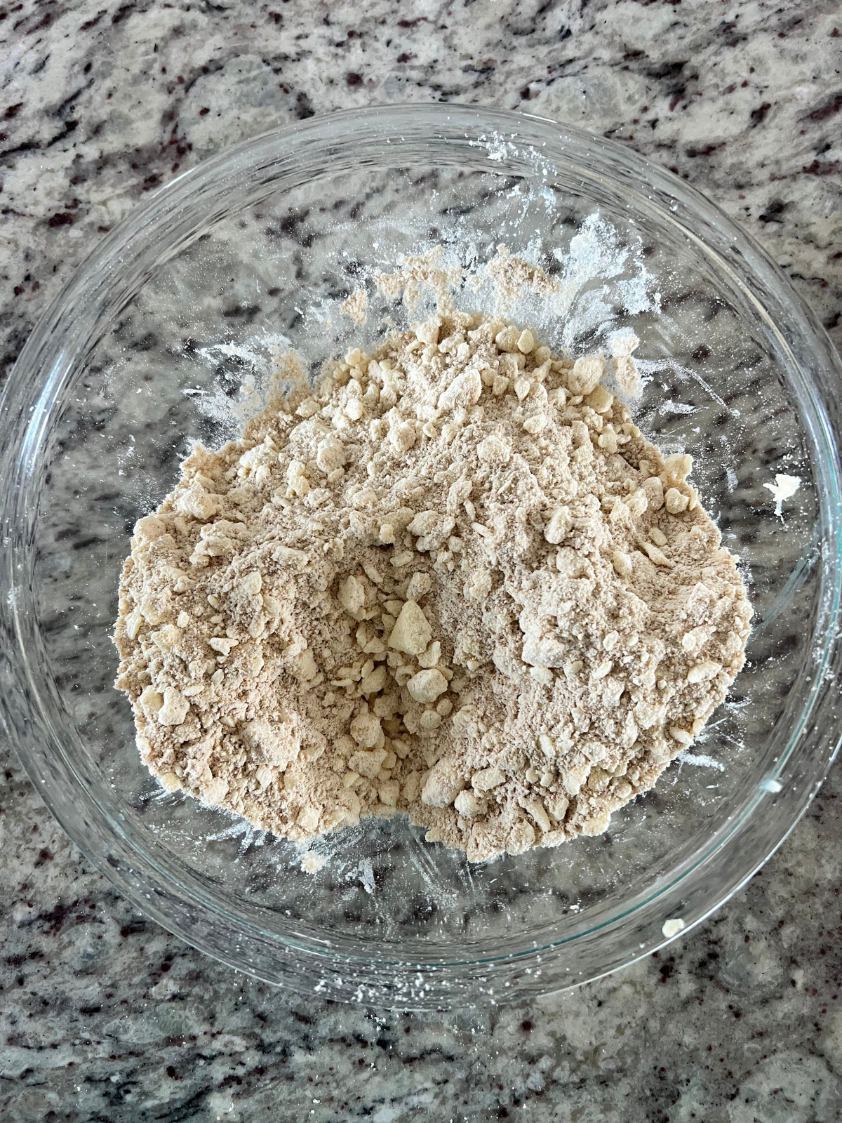 The dry ingredients and the grated butter is shown in a glass mixing bowl for the sourdough s'mores pop tarts. 
