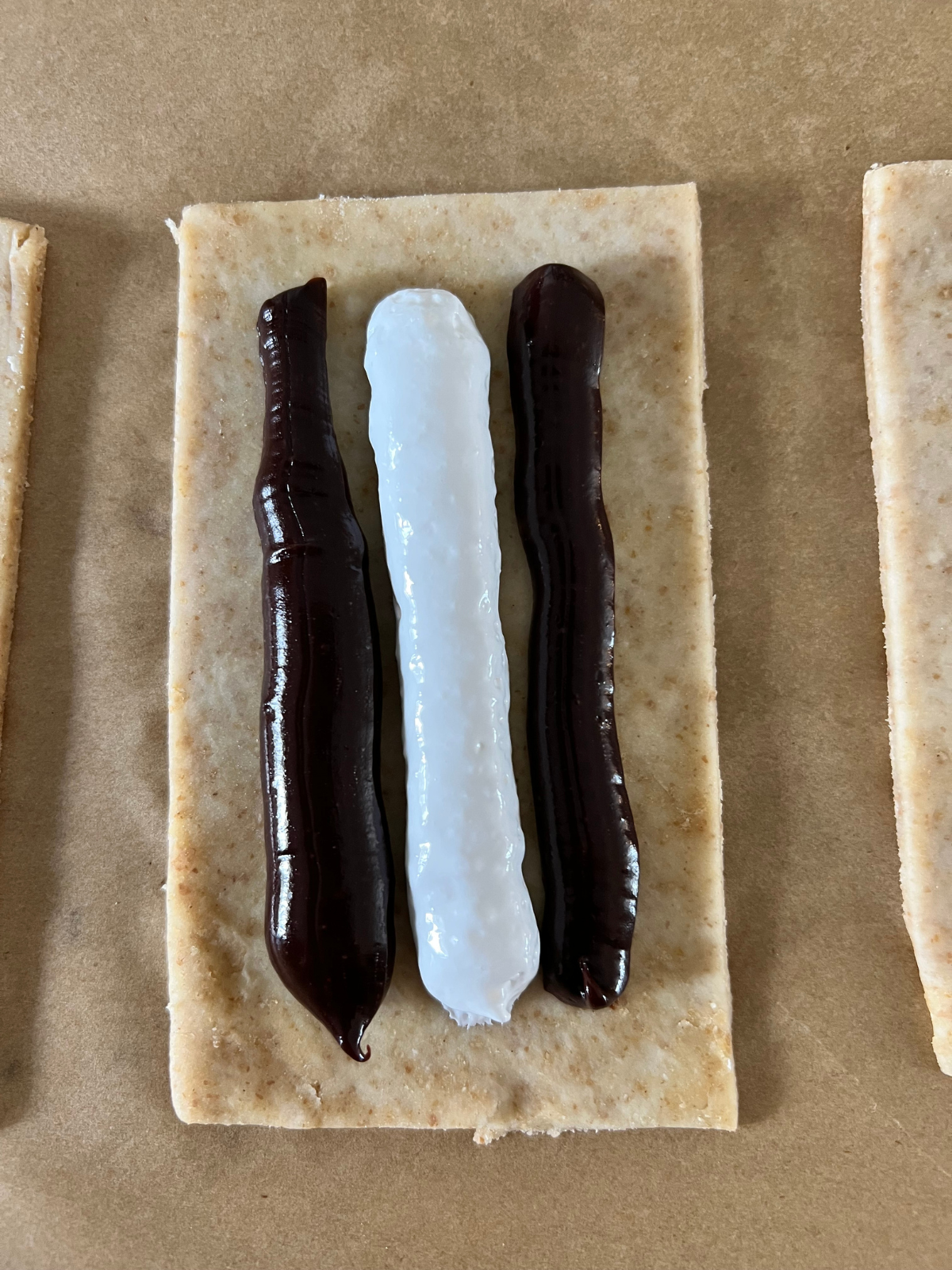 The chocolate ganache filling and marshmallow fluff is shown piped on the dough.