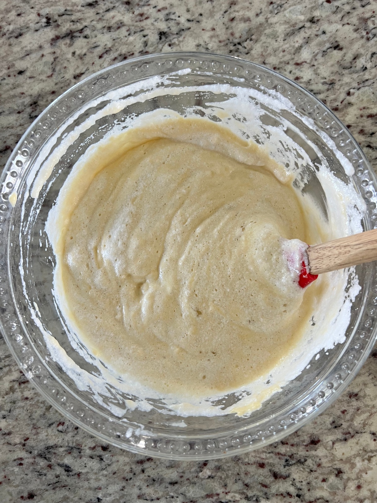The sourdough tres leches cake batter sits in a glass mixing bowl.