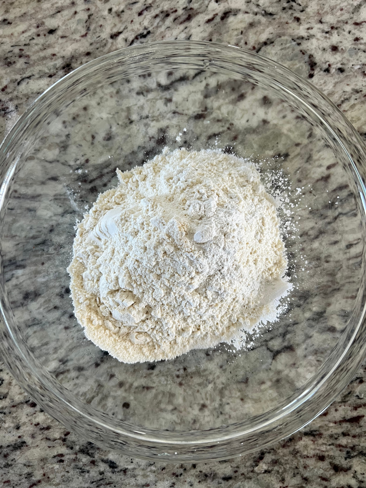 The dry ingredients sit in a glass mixing bowl for the sourdough tres leches cake.