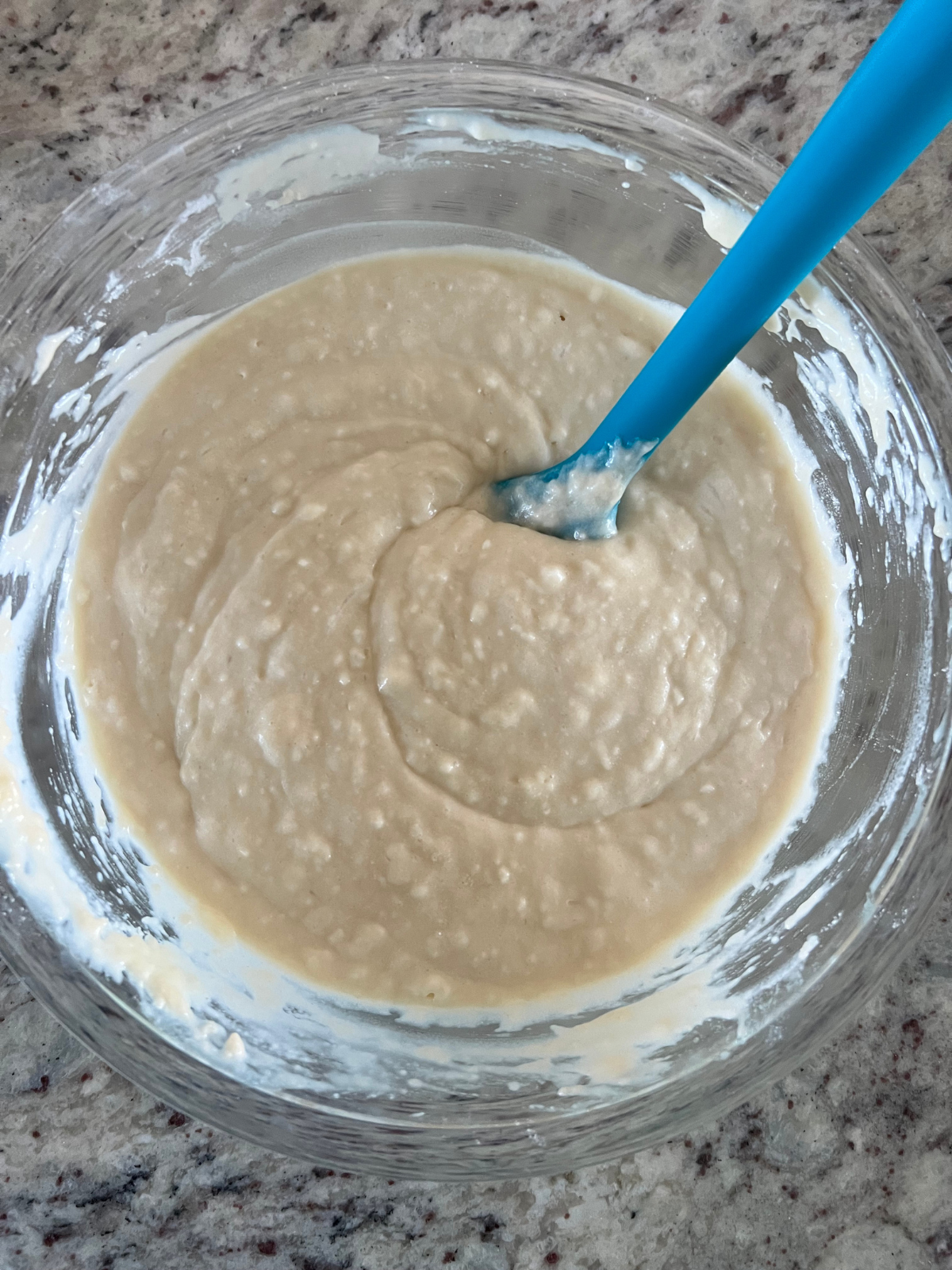 The sourdough cake batter for the dot cakes sit in a glass mixing bowl.
