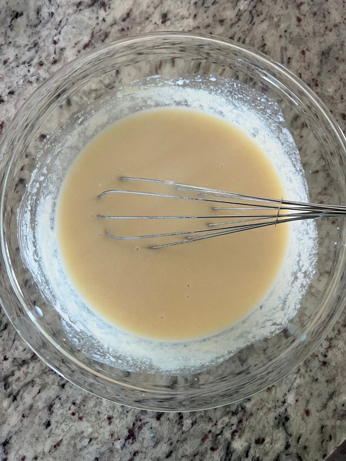 The wet ingredients sit in a glass mixing bowl for the sourdough discard dot cakes.