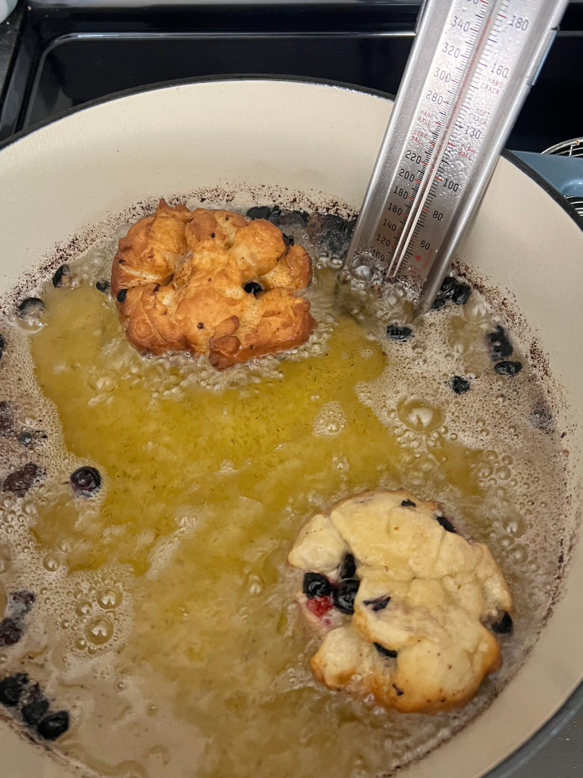 The sourdough fritters are shown in the pan frying in the hot oil.