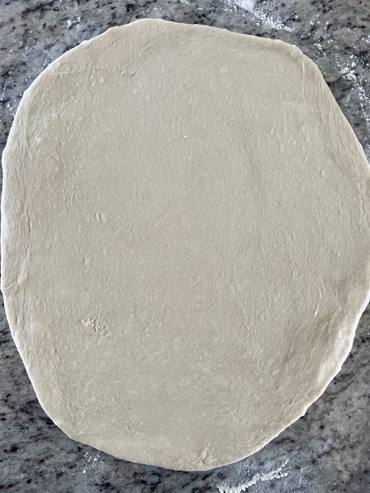 The sourdough fritter dough is shown rolled out on the counter.