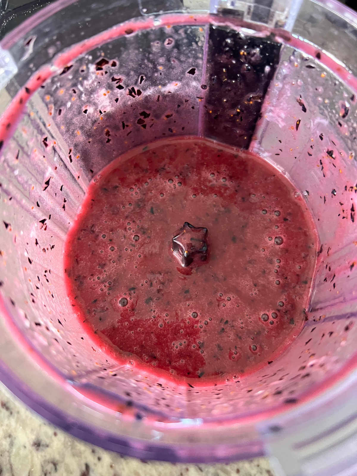 The blueberry lemon glaze is shown after being blended in the food processor.