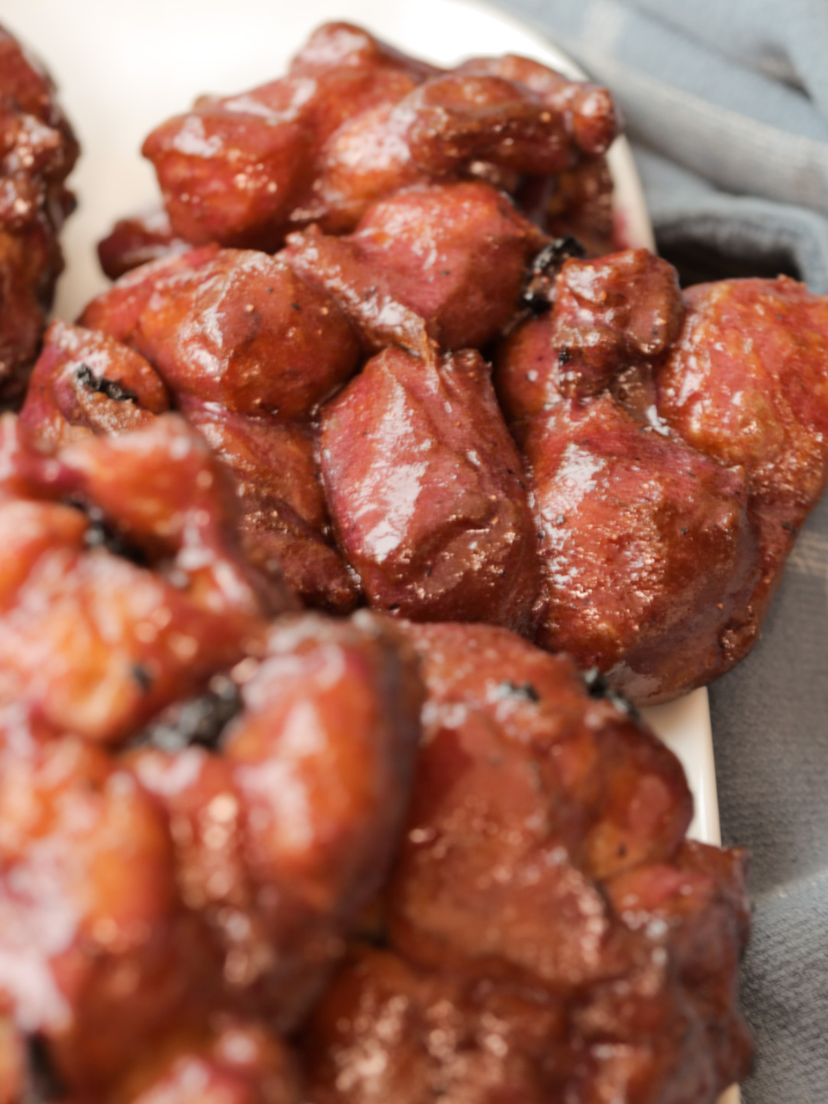 A closeup of a sourdough lemon blueberry fritter is shown with several others in the background.