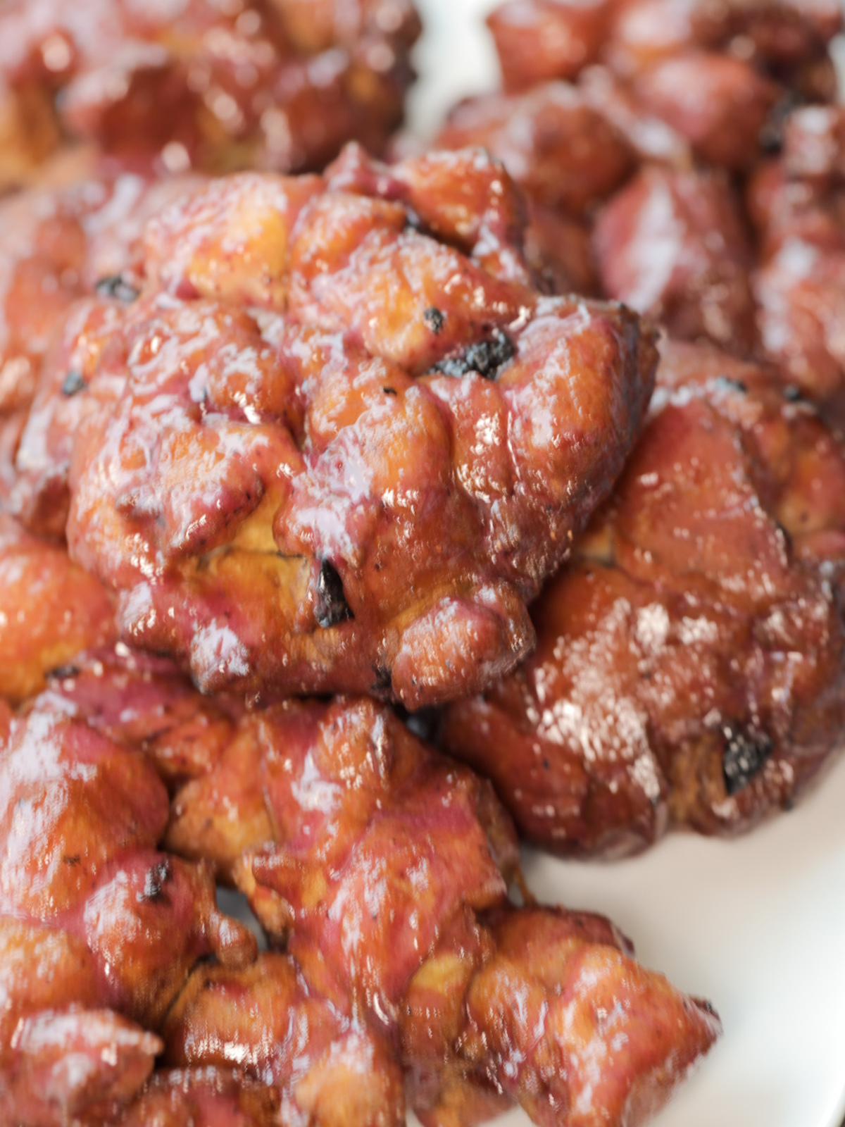 Homemade sourdough lemon blueberry fritters sit on a platter.