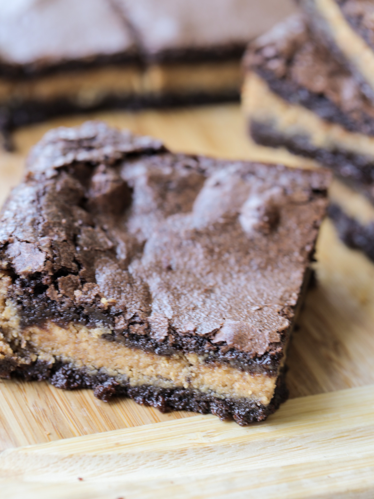 A closeup of one sourdough discard peanut butter brownie is shown with several other brownies in the background.