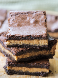 Three rich and chewy sourdough discard brownies with peanut butter centers are stacked on top of each other.