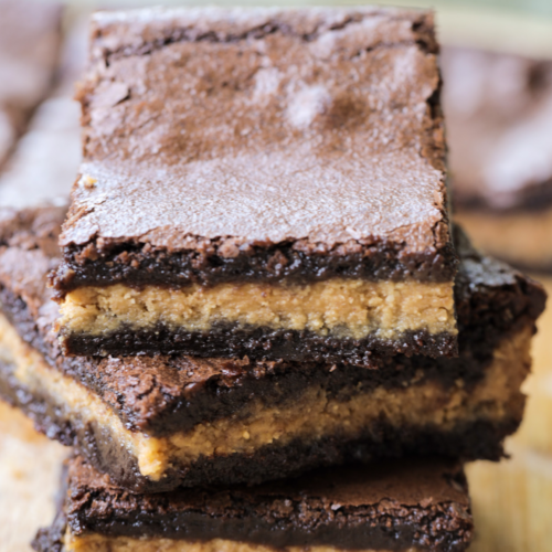 Three rich and chewy sourdough discard brownies with peanut butter centers are stacked on top of each other.