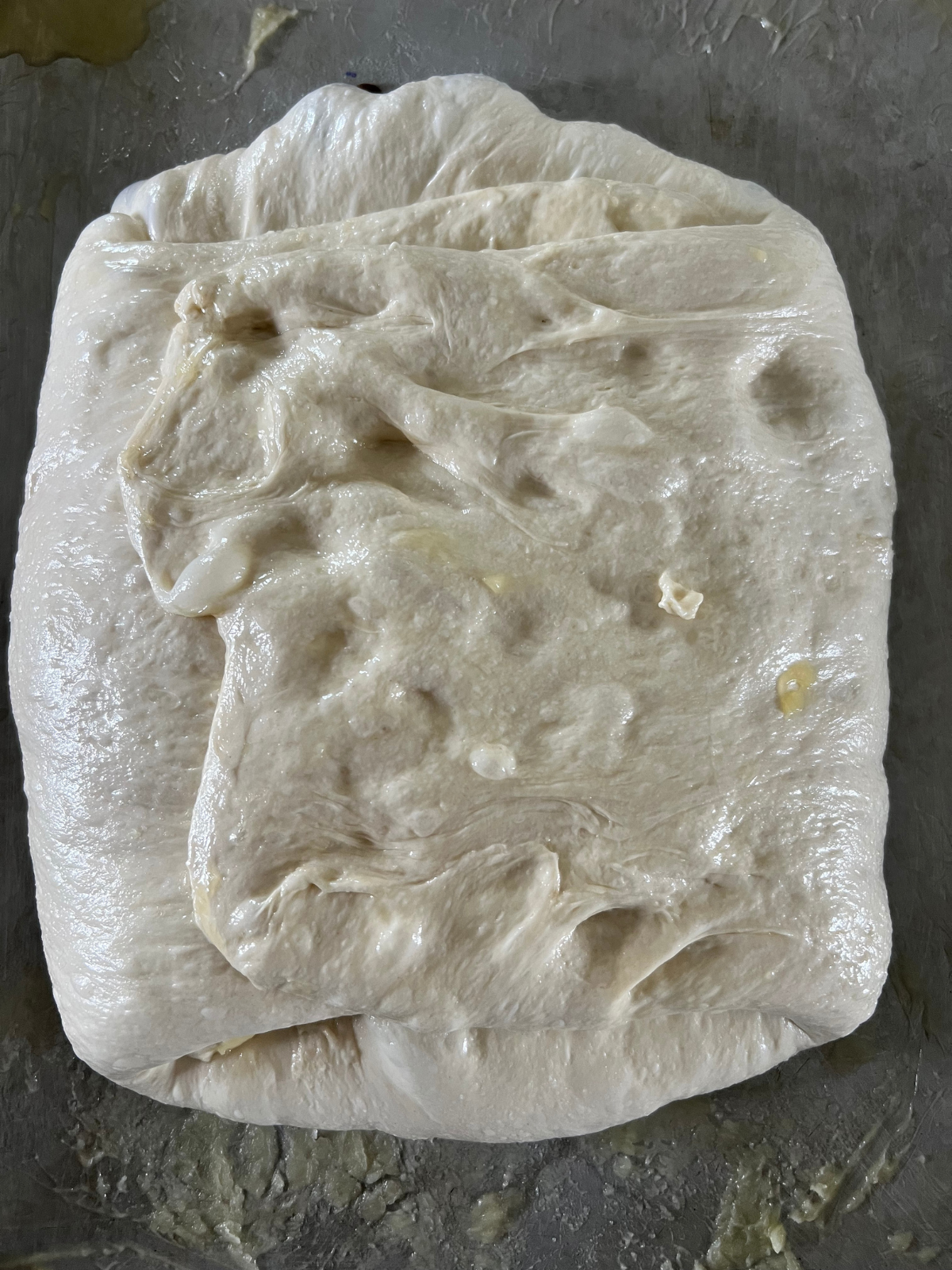 The sourdough focaccia dough has been folded over the peach filling.