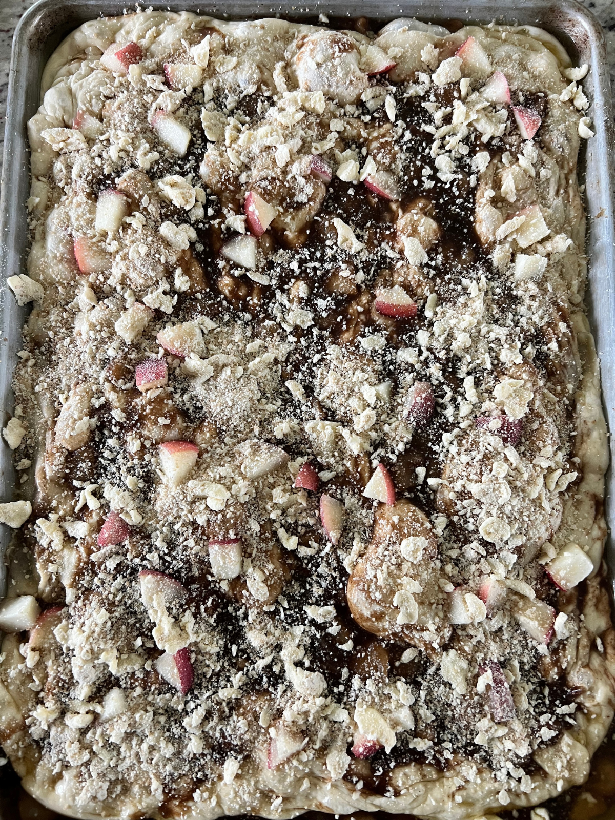 The fully fermented sourdough focaccia dough is shown with the peach filling and crumble sprinkled over the top.