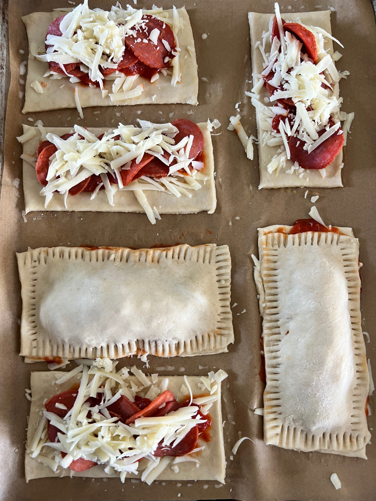The filling has been added to the hot pockets. The tops of the dough rectangles will be added and crimped. 