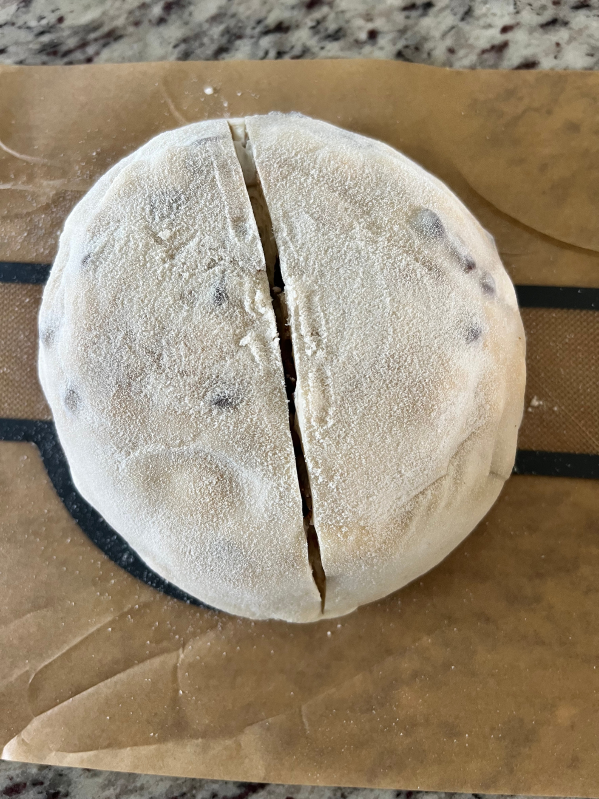 The sourdough loaf has been scored and is ready to bake. 