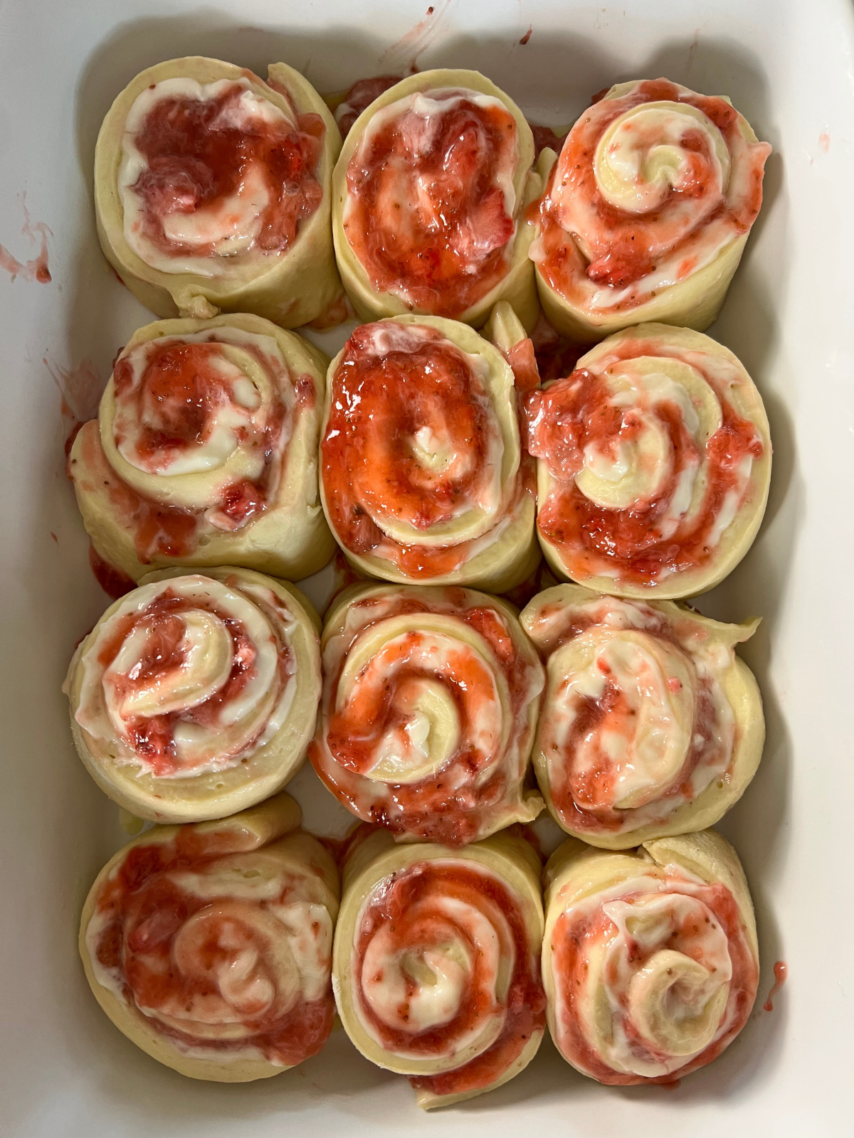 The sourdough strawberry cheesecake sweet rolls are shown shaped sitting in the baking pan after their second rise.