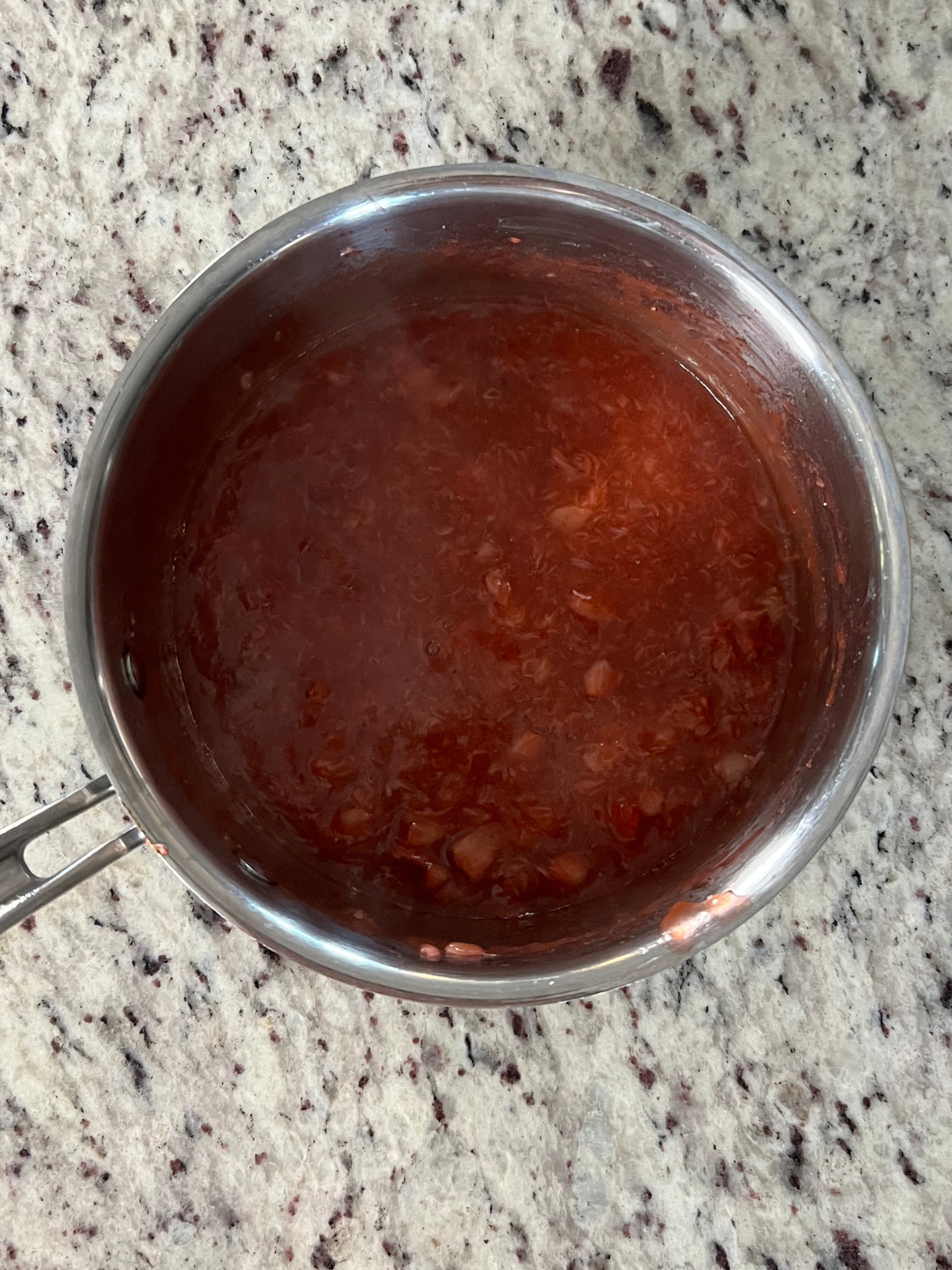 The strawberry filling sits in the medium sized saucepan. It will cool before you add it to the dough.
