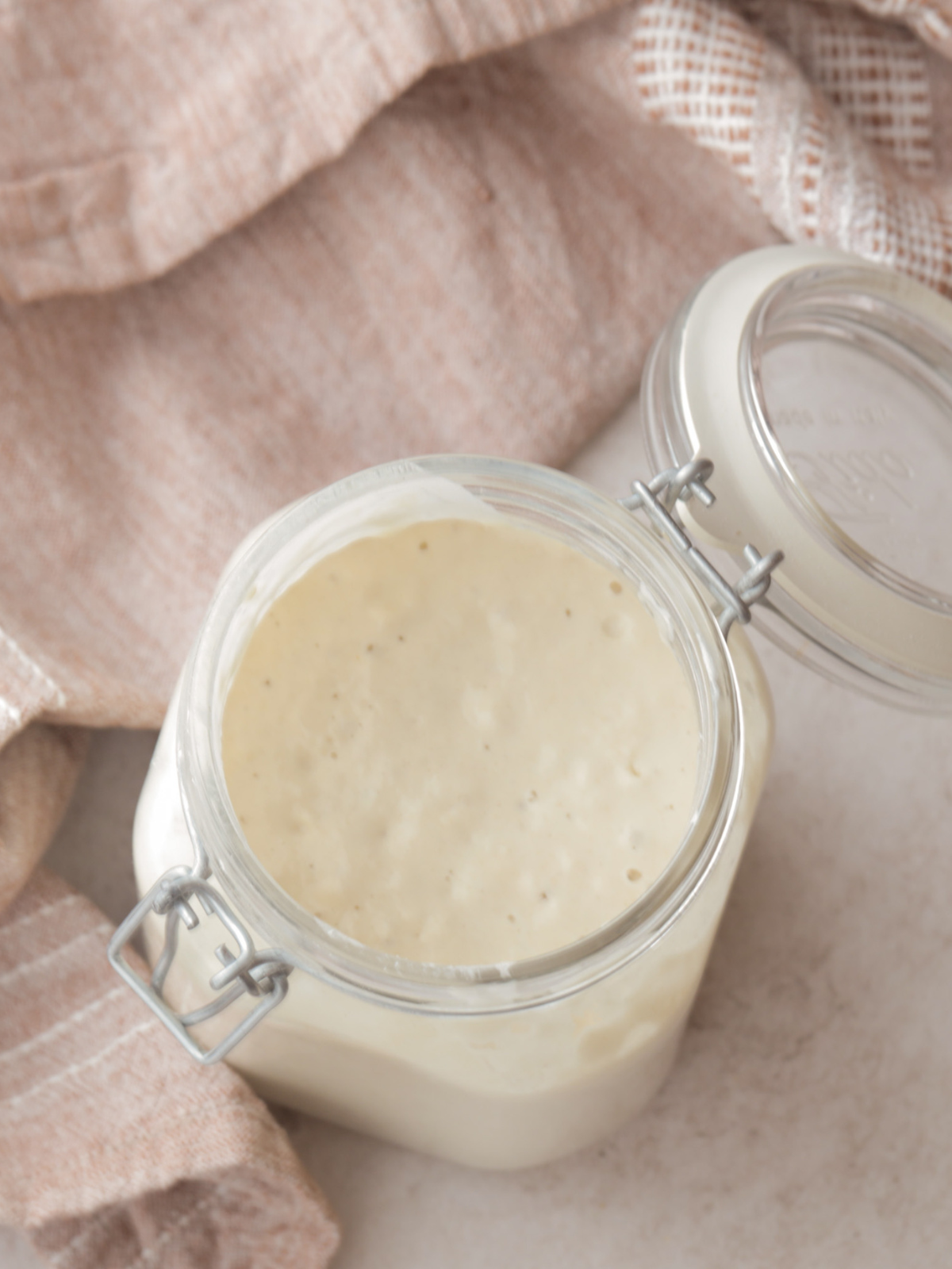 Sourdough starter is shown bubbly and in a jar.