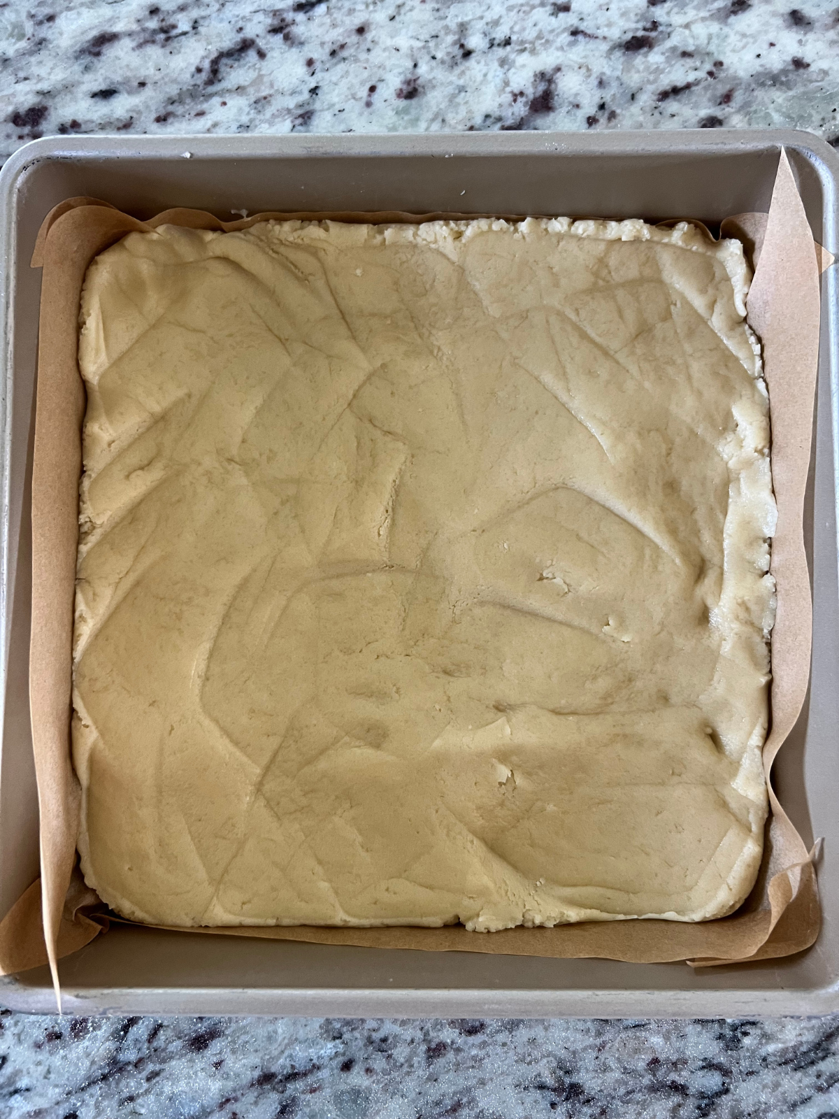 The sourdough sugar cookie dough is shown pressed down into the pan.