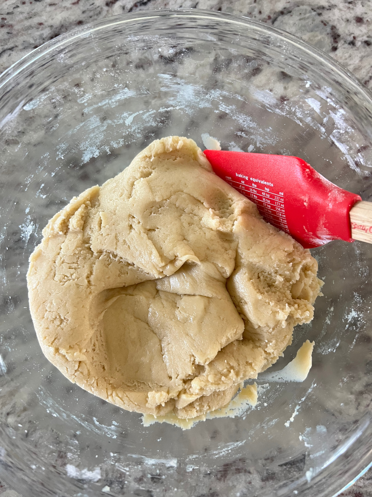 The sourdough discard sugar cookie crust dough sits in a glass mixing bowl.