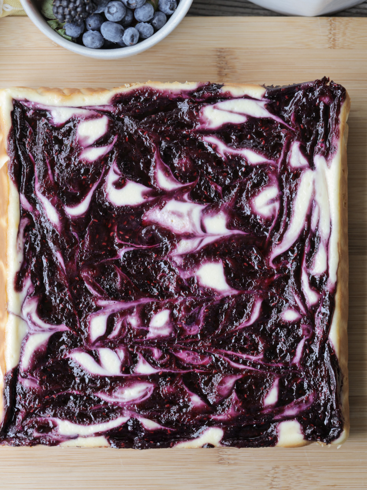 The baked, cooled, and chilled full berry swirl cheesecake is shown, ready to be sliced and enjoyed!