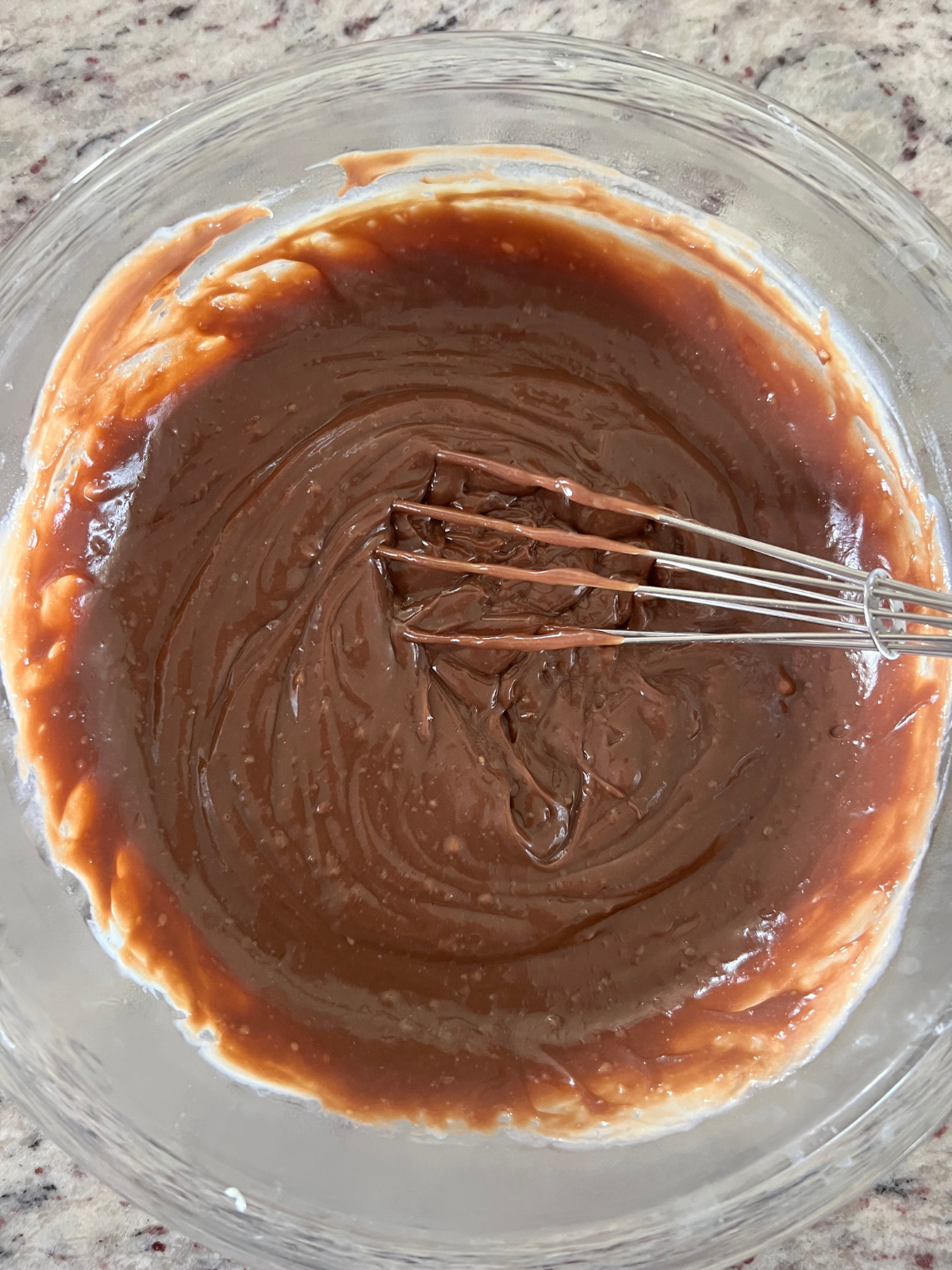 The chocolate melting wafers have melted into the custard, making it a chocolate custard that will be chilling in the fridge until the donuts are ready to be filled.