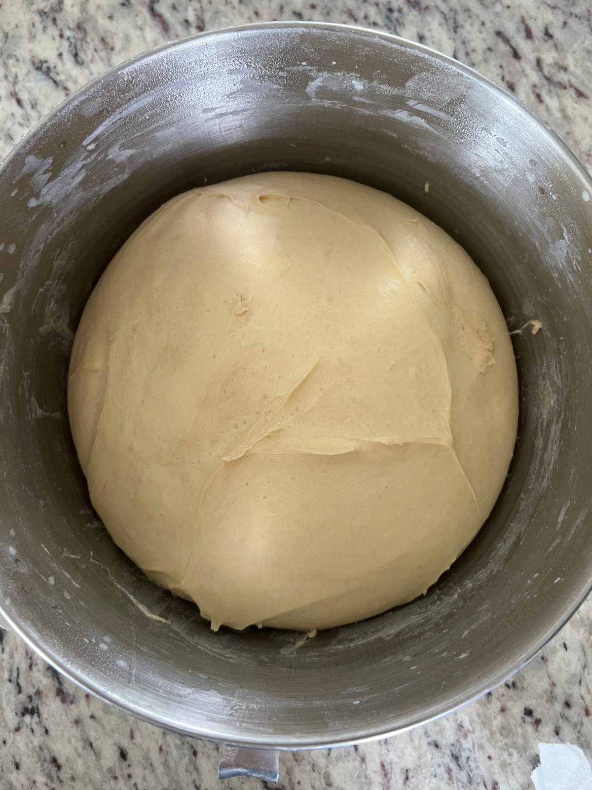 The fully fermented sourdough brioche donut dough is shown in a mixing bowl.
