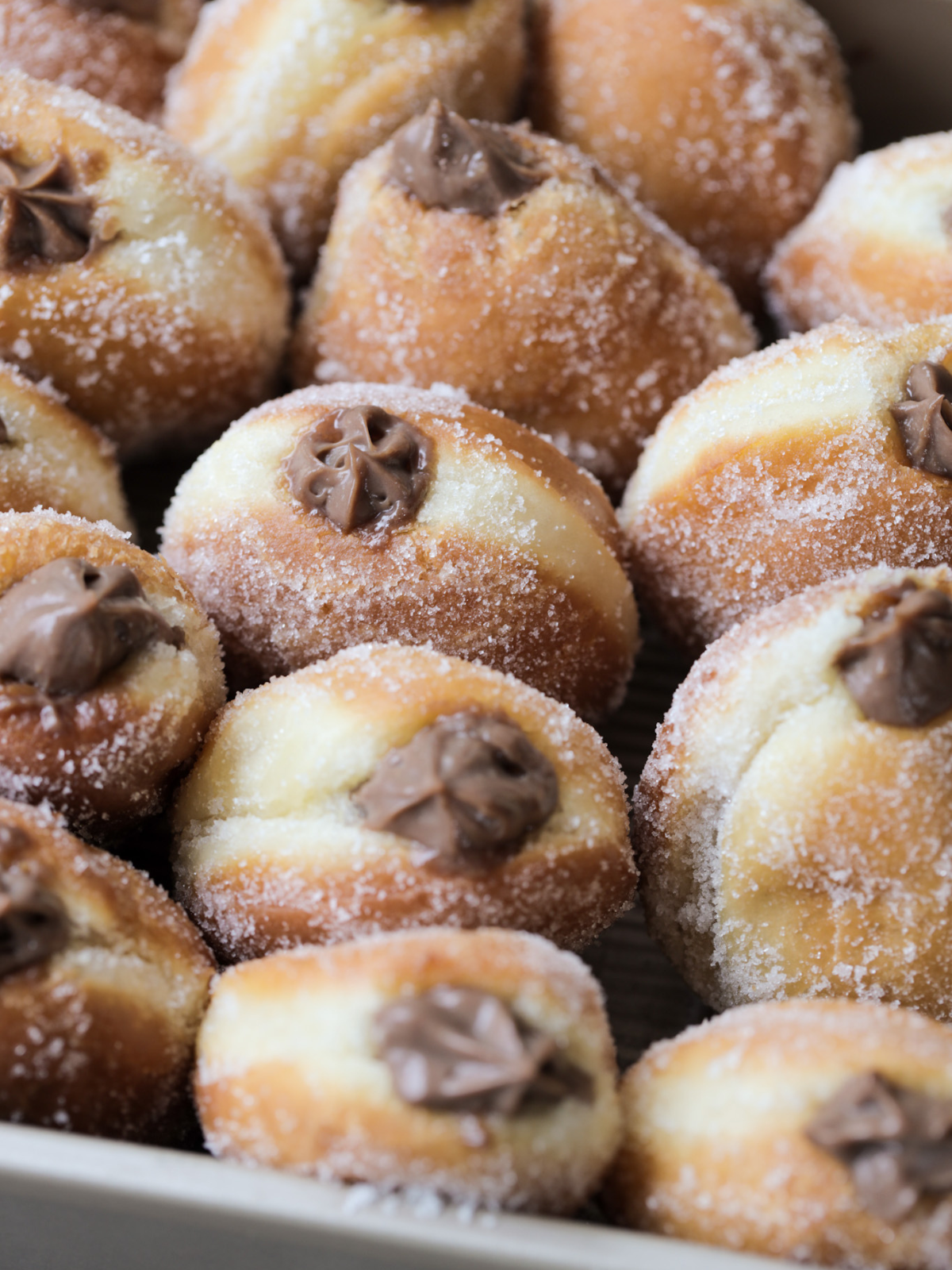 The sourdough donuts with chocolate custard filling are shown together in a pan. 