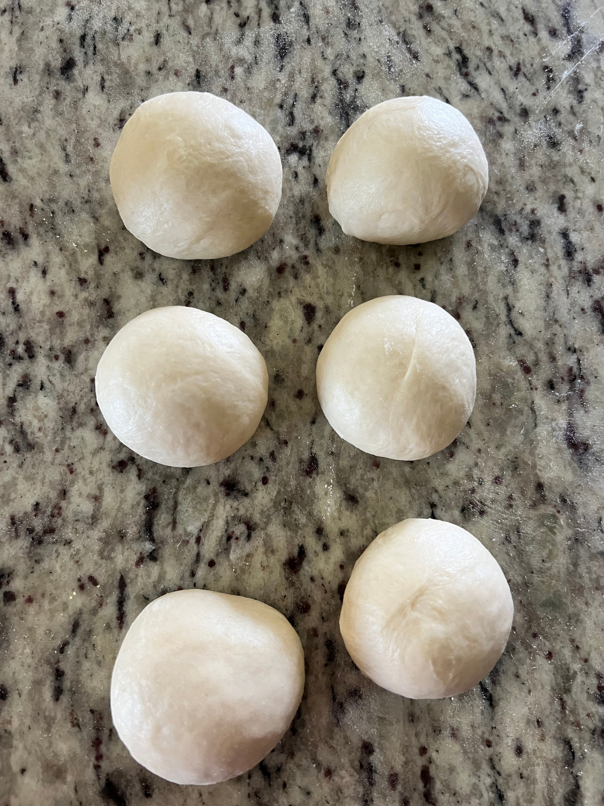 The sourdough dough balls are shown shaped into a nice, round ball.