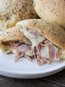Sourdough ham and Swiss cheese pocket is shown cut in half with melty Swiss cheese and sliced ham.