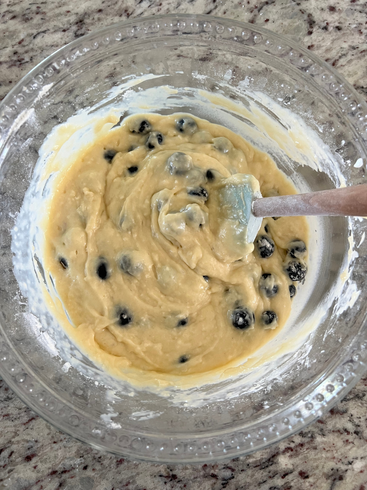 The sourdough discard blueberry muffin batter rests in a glass mixing bowl.