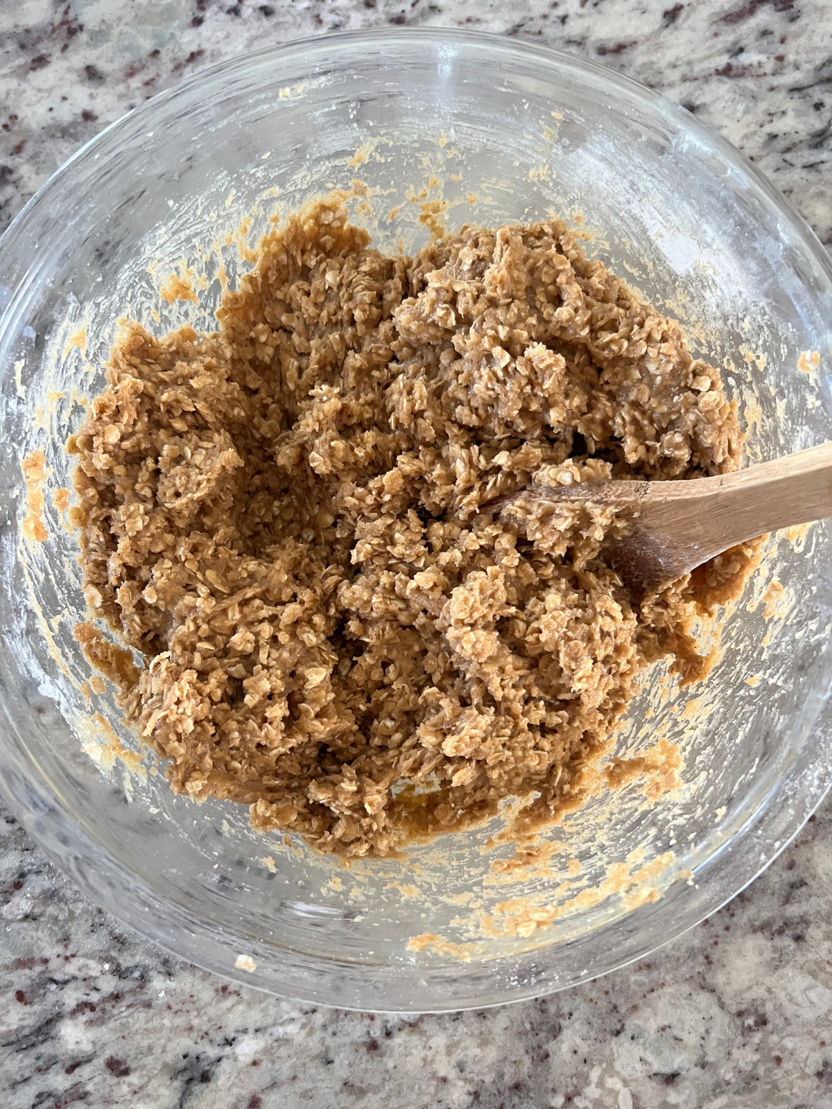 The cookie dough for the sourdough brown butter caramel apple oatmeal cream pies sit in a glass mixing bowl. 
