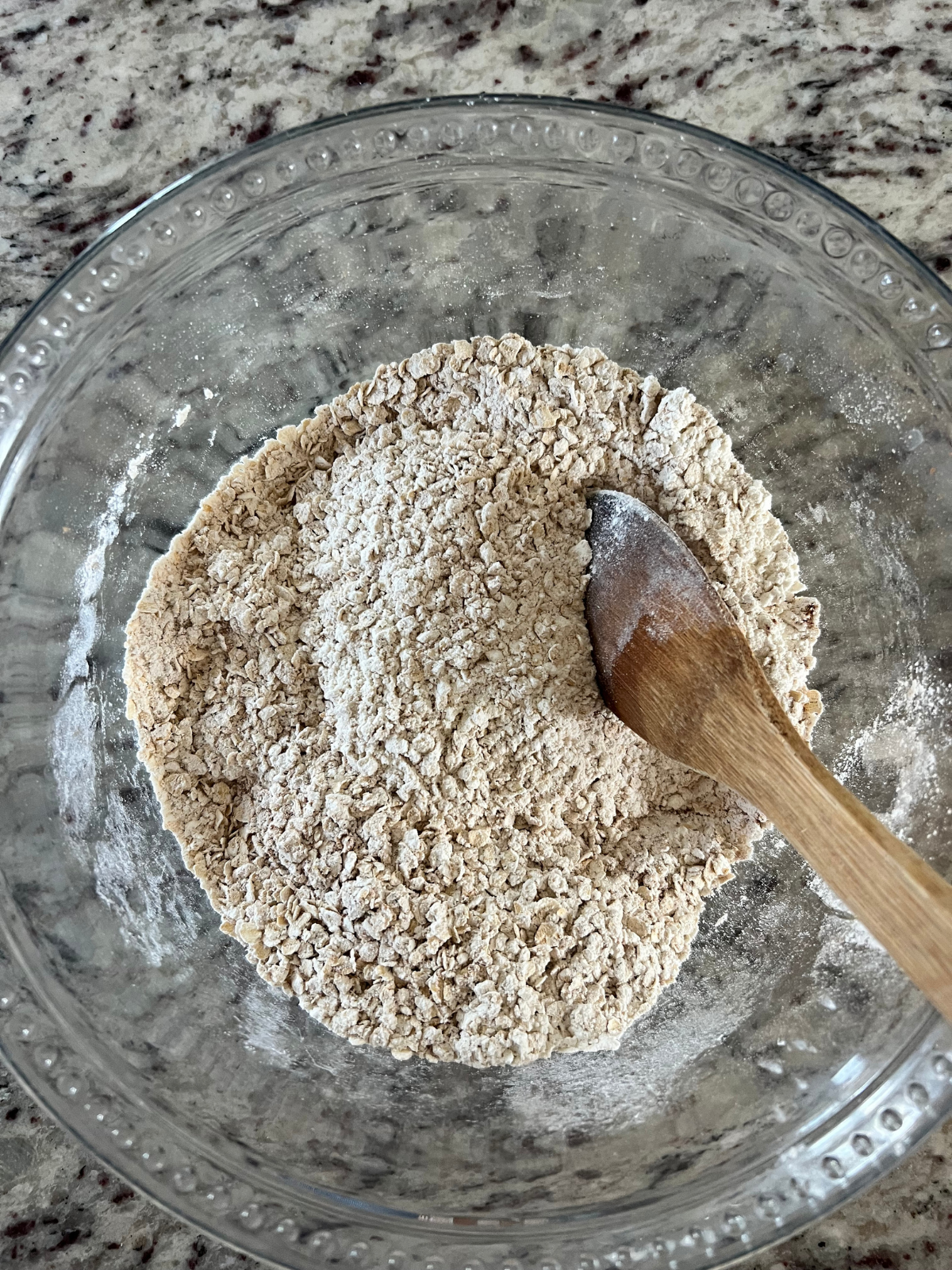 The dry ingredients for the sourdough brown butter caramel apple oatmeal cream pies sit in a glass mixing bowl. 